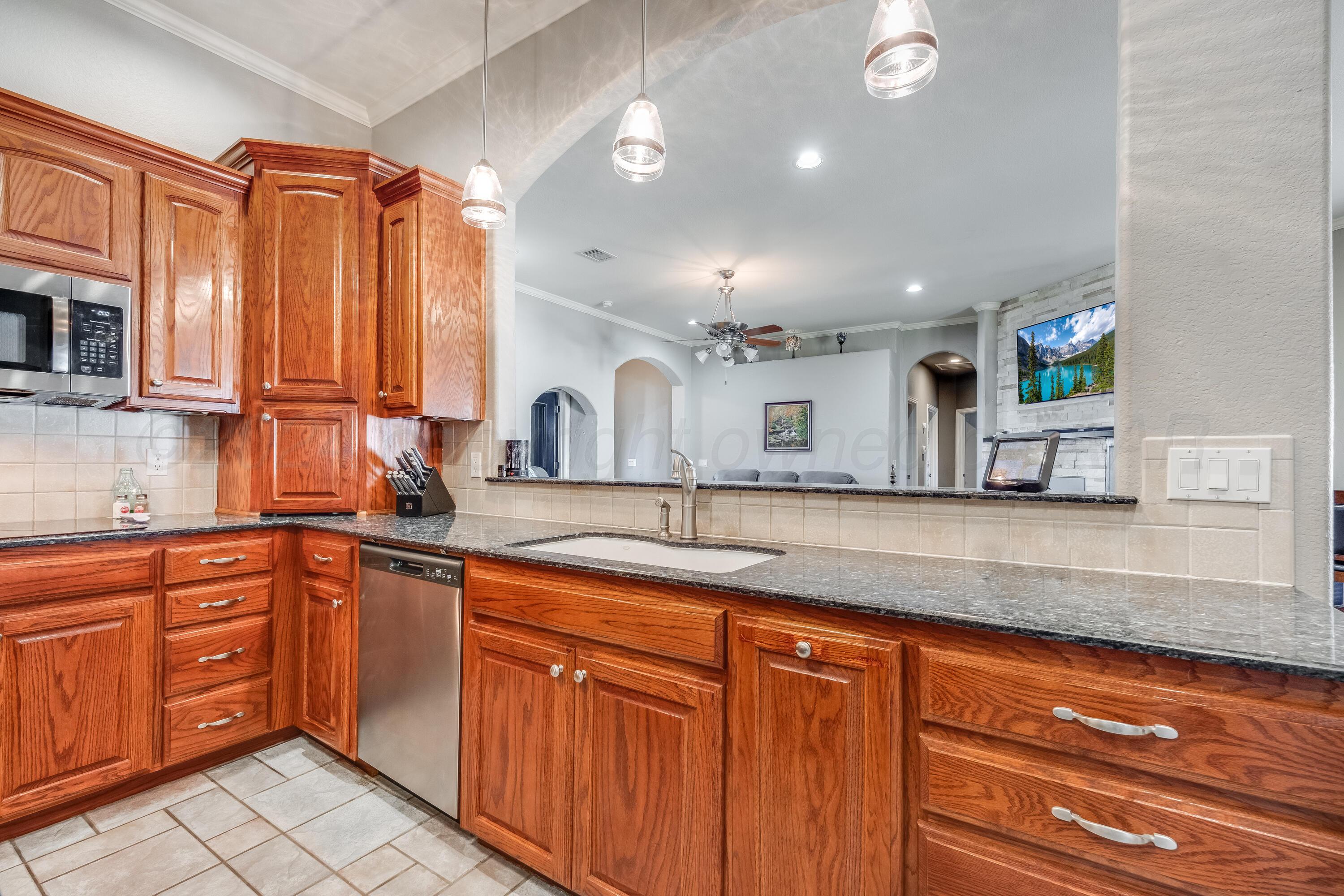 8413 Hamilton Drive Amarillo, TX 79119 - Photo 13 of 54 a kitchen with stainless steel appliances granite countertop a sink and cabinets