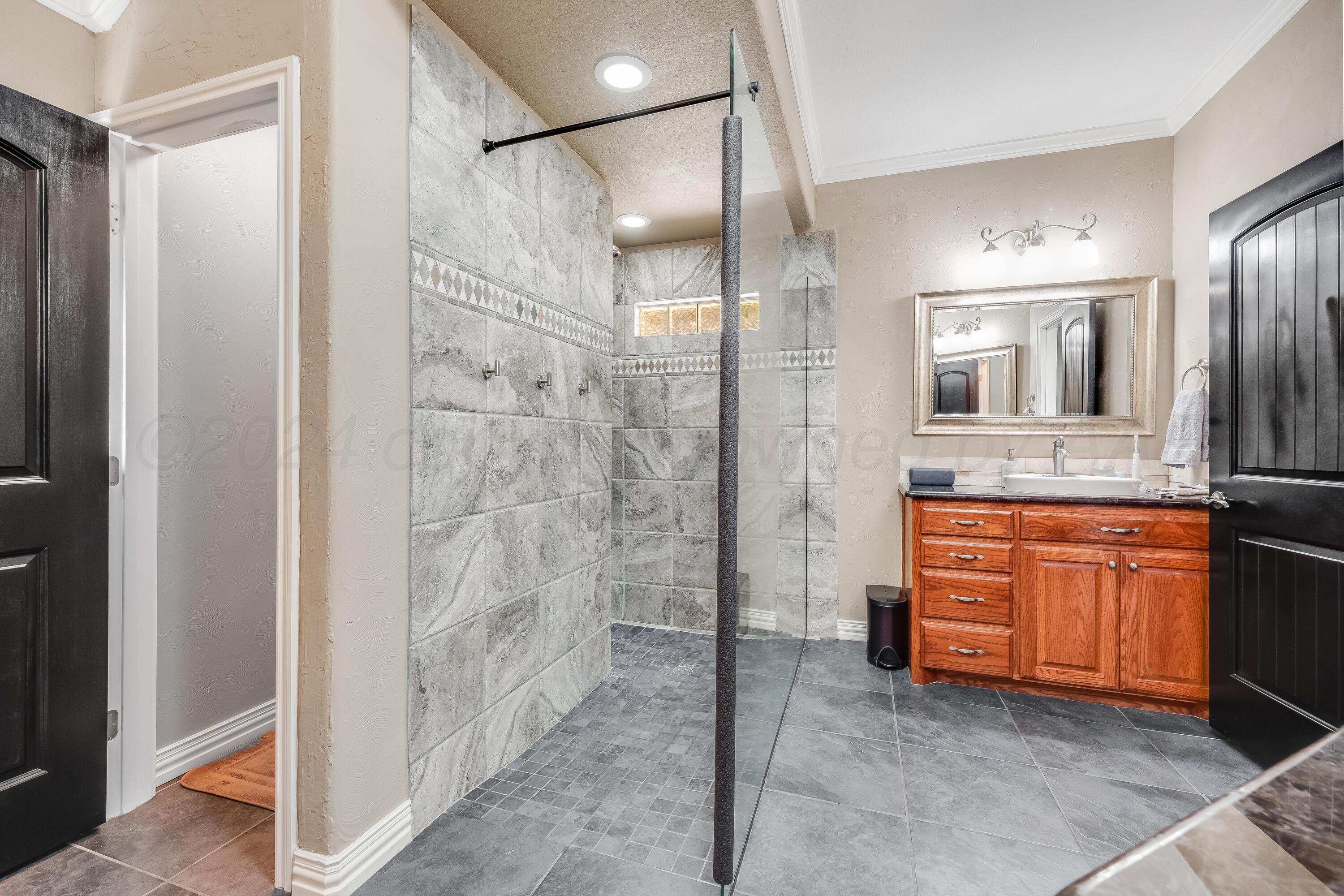 8413 Hamilton Drive Amarillo, TX 79119 - Photo 25 of 54 a bathroom with a granite countertop sink mirror and shower