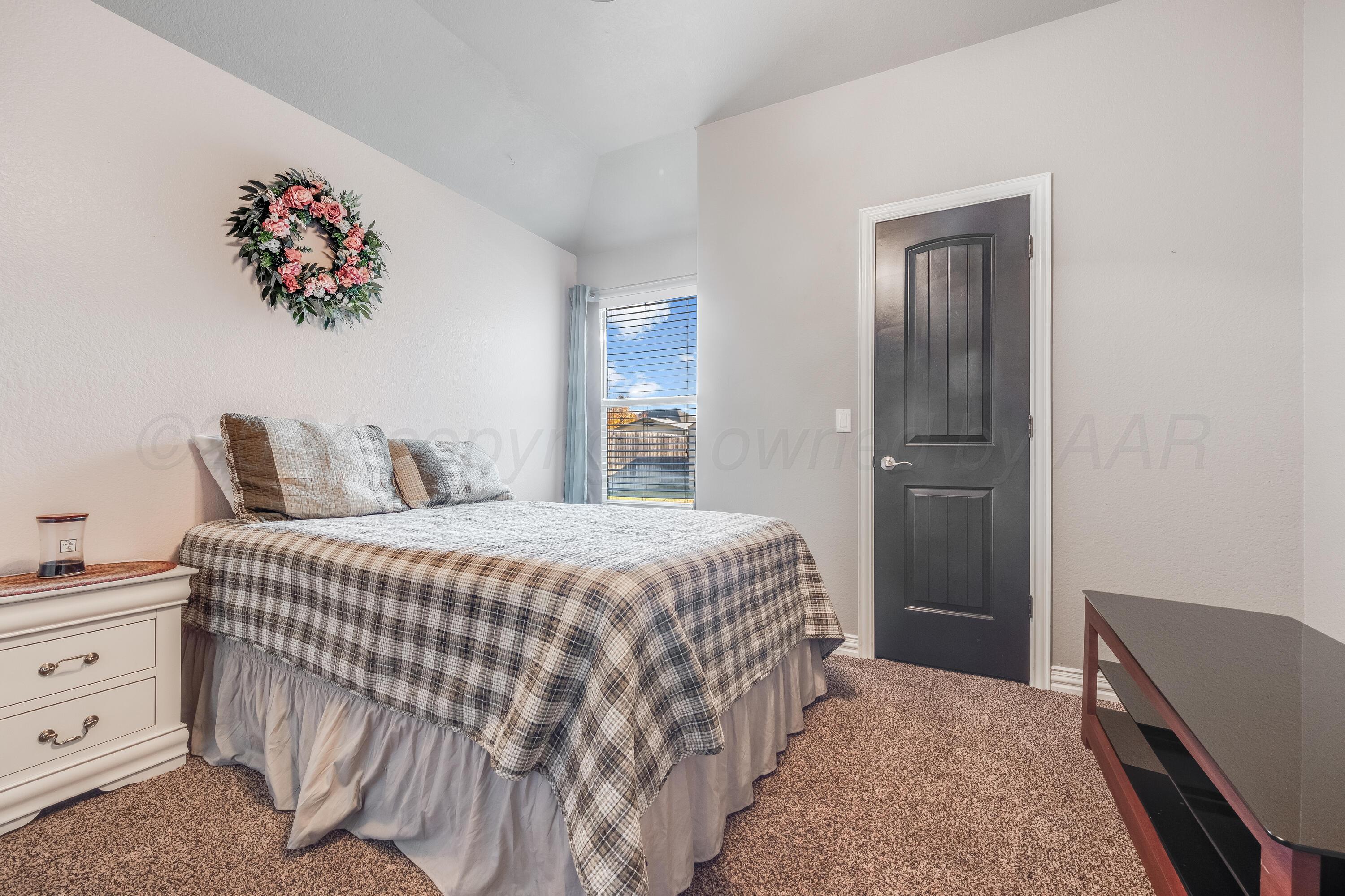 8413 Hamilton Drive Amarillo, TX 79119 - Photo 28 of 54 a bedroom with a bed and a chandelier