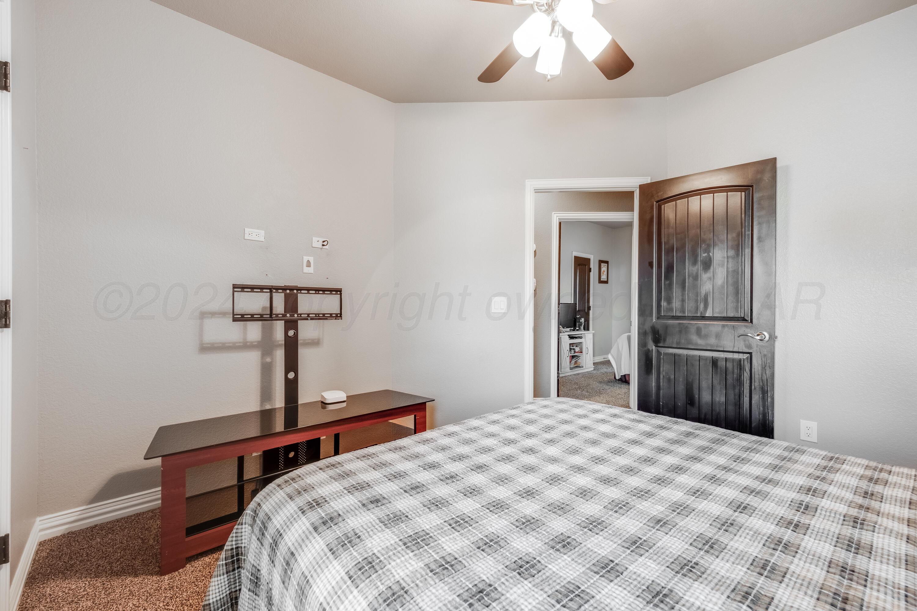 8413 Hamilton Drive Amarillo, TX 79119 - Photo 29 of 54 a bedroom with a bed and a chandelier