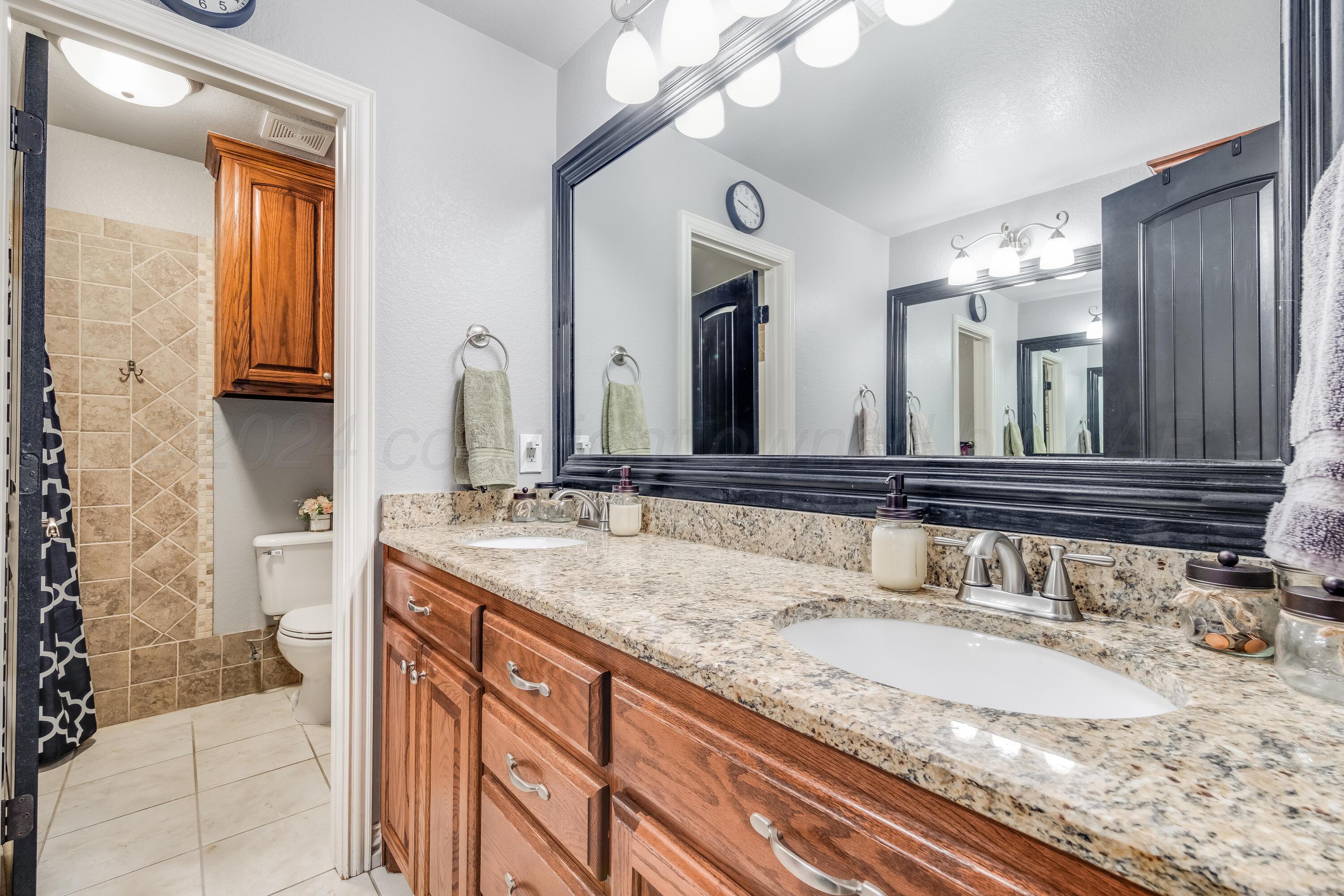 8413 Hamilton Drive Amarillo, TX 79119 - Photo 30 of 54 a bathroom with a granite countertop sink double vanity and a mirror