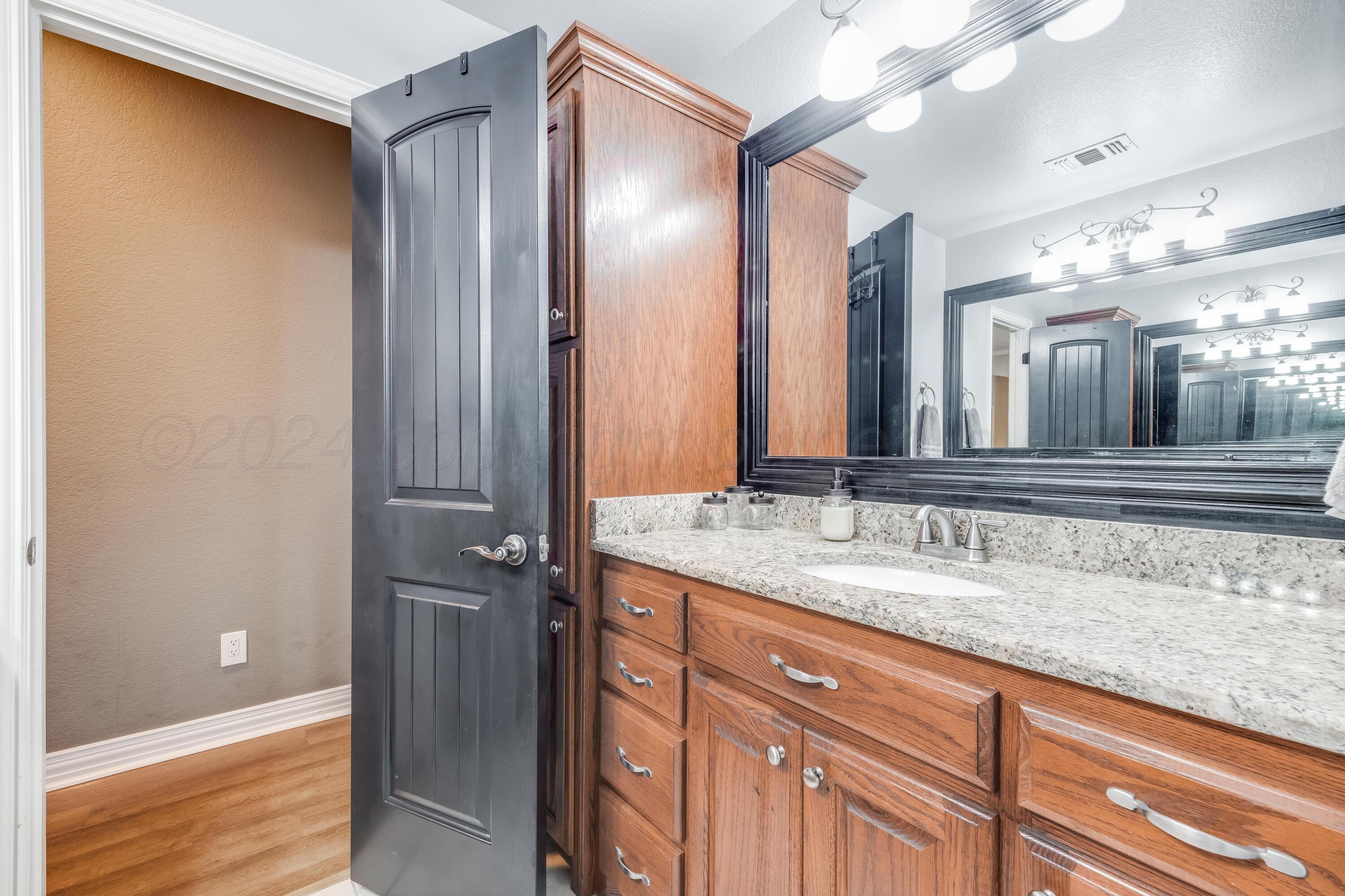 8413 Hamilton Drive Amarillo, TX 79119 - Photo 31 of 54 a bathroom with a granite countertop sink and a mirror