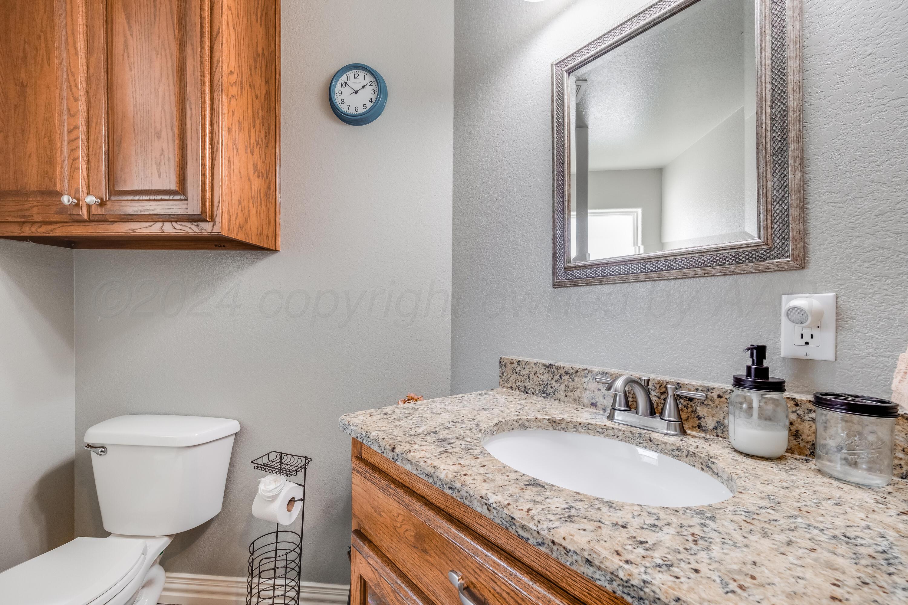 8413 Hamilton Drive Amarillo, TX 79119 - Photo 35 of 54 a bathroom with a granite countertop toilet sink and mirror