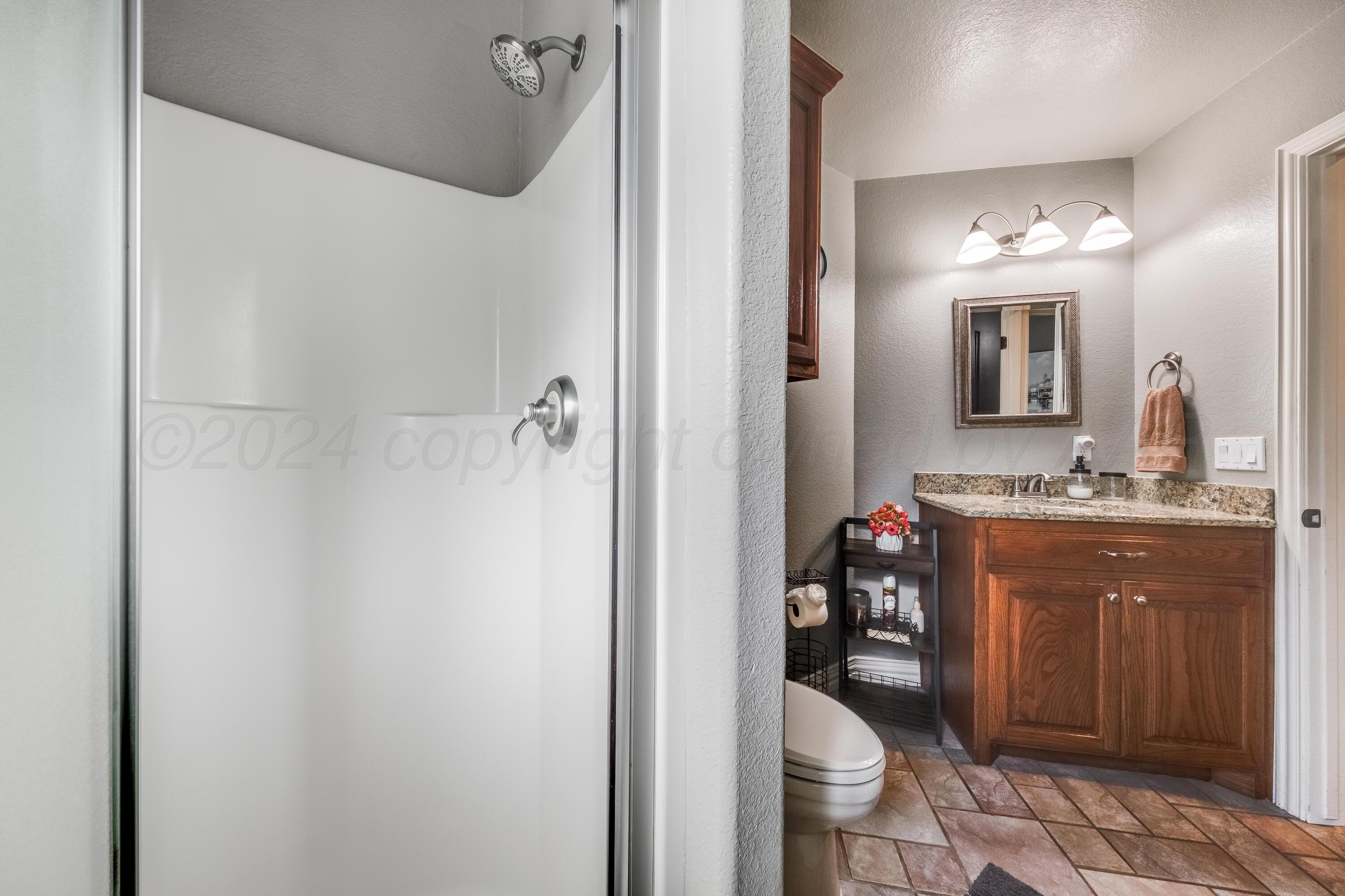 8413 Hamilton Drive Amarillo, TX 79119 - Photo 36 of 54 a bathroom with a granite countertop sink toilet and mirror