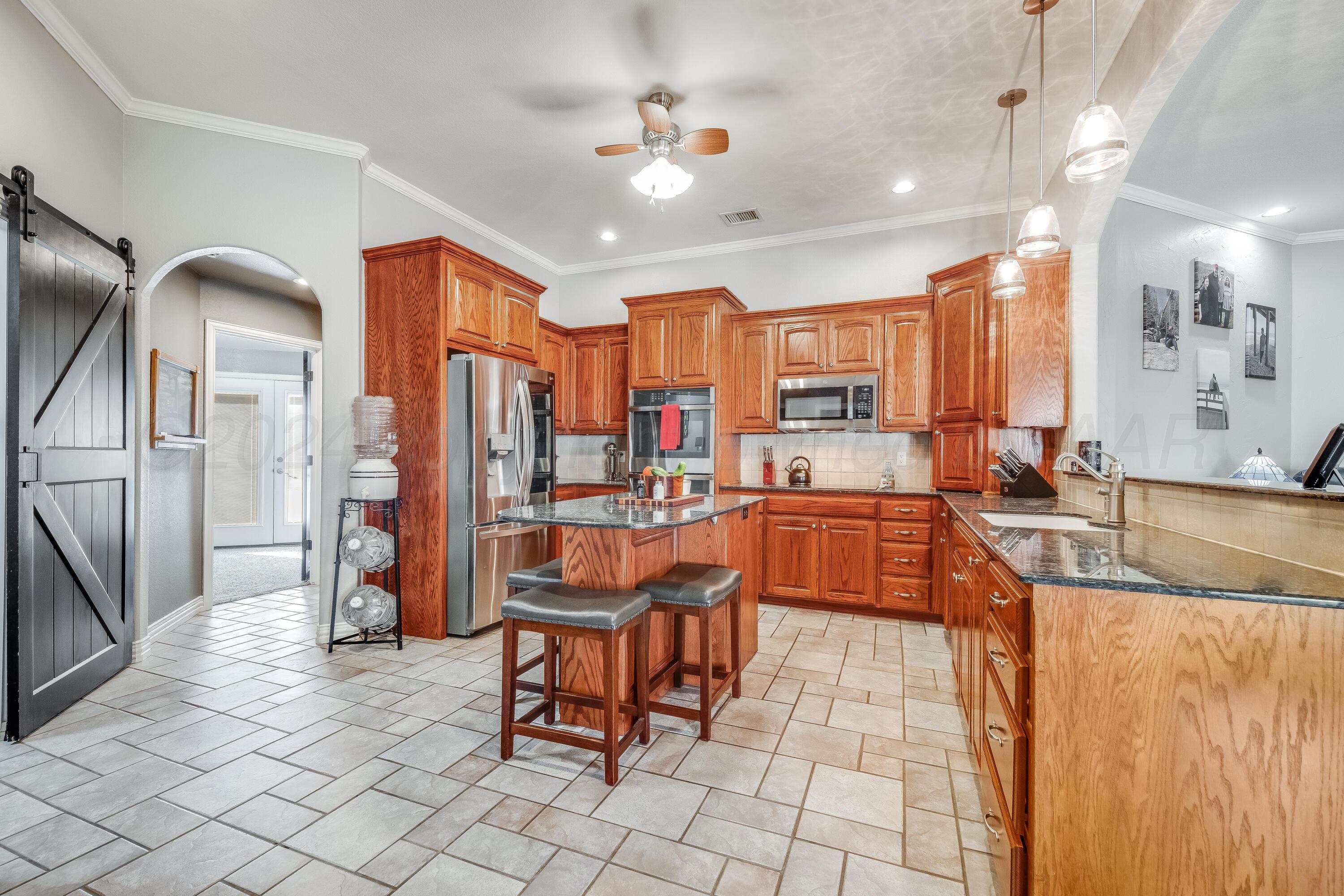 8413 Hamilton Drive Amarillo, TX 79119 - Photo 9 of 54 a large white kitchen with a large window and stainless steel appliances