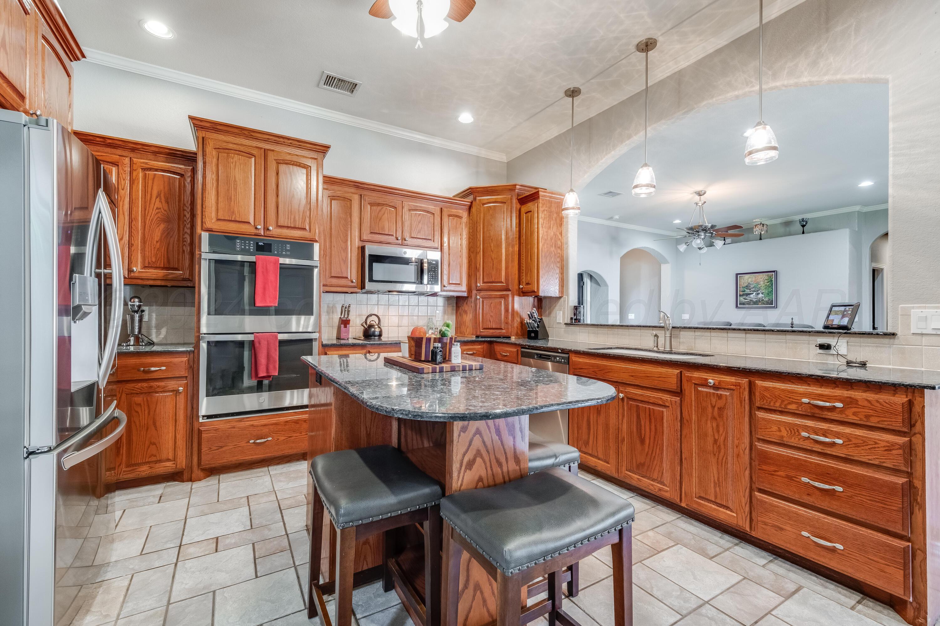 8413 Hamilton Drive Amarillo, TX 79119 - Photo 10 of 54 a kitchen with stainless steel appliances granite countertop a sink stove and refrigerator