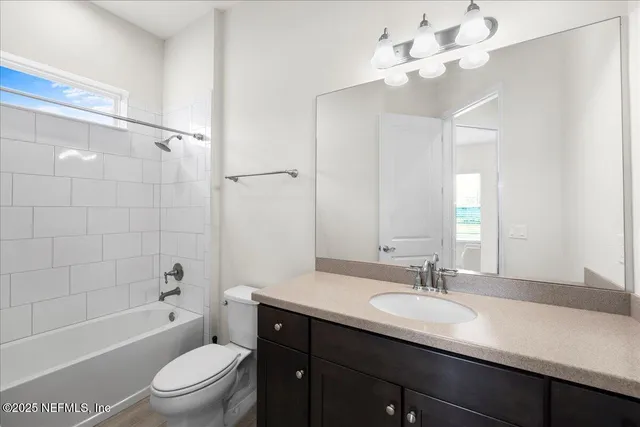 a bathroom with a sink a toilet a mirror a bathtub and shower