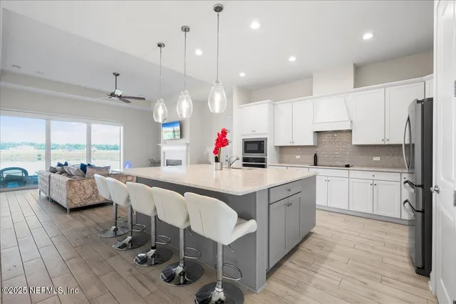 a large kitchen with stainless steel appliances lots of counter space dining table and chairs