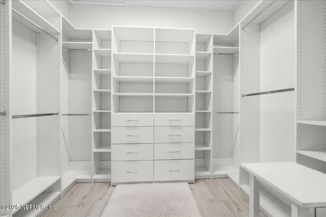 a view of walk in closet with empty racks