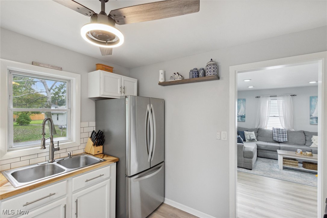373 Erie Road Vermilion, OH 44089 - Photo 15 of 29 Kitchen with tasteful backsplash, a wealth of natural light, sink, and white cabinets