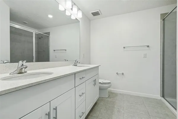 a bathroom with a double vanity sink toilet and a mirror