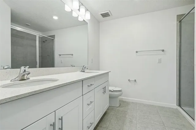 a bathroom with a double vanity sink toilet and a mirror