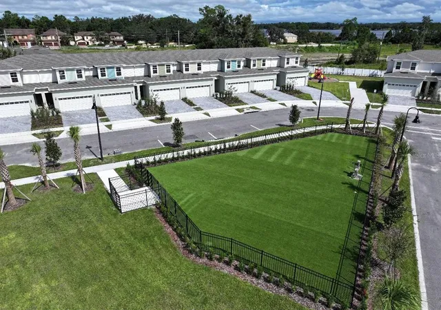 an aerial view of a house with a garden and lake view