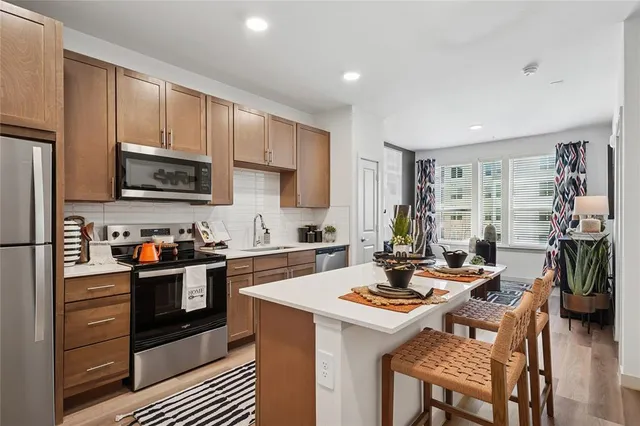 a kitchen with a stove a sink dishwasher and a refrigerator with wooden cabinets