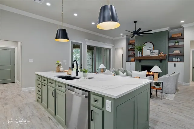 a kitchen with a stove a sink and a wooden floor