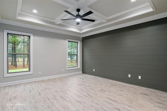 a view of an empty room with a window and a ceiling fan