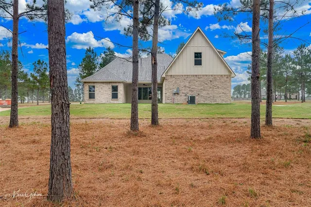 a front view of a house with a yard and trees