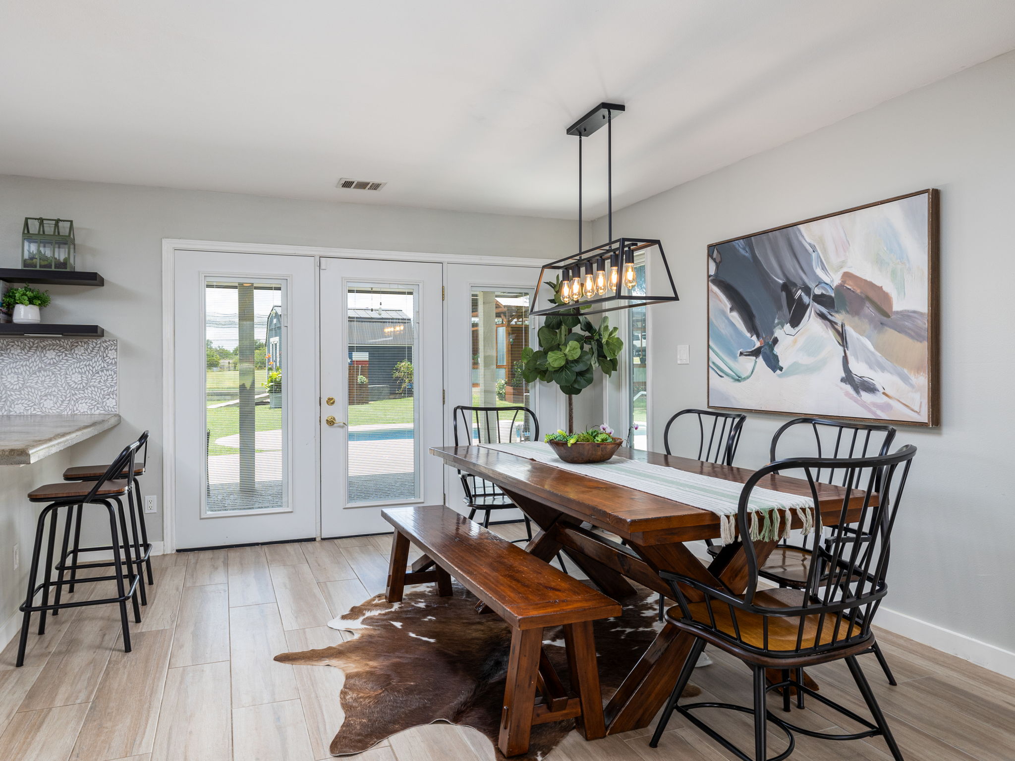 3001 County Road 255 Georgetown, TX 78633 - Photo 11 of 35 A well-lit dining area featuring French doors leading to the outdoors and a sleek, contemporary light fixture.