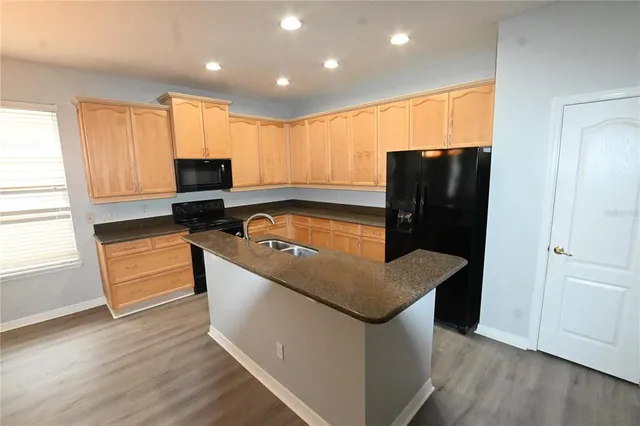 a kitchen with stainless steel appliances granite countertop a refrigerator a stove a sink and a microwave