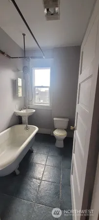 a bathroom with a sink a toilet a window and vanity