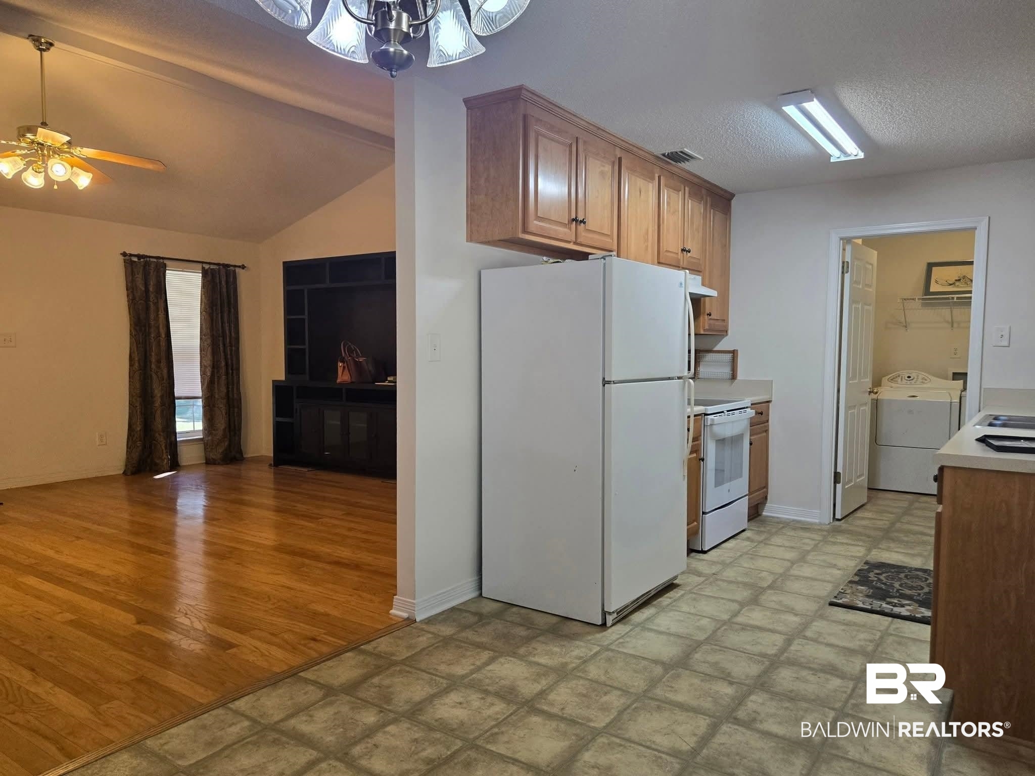 2554 Riverside Drive Mobile, AL 36605 - Photo 7 of 43 Kitchen featuring white appliances, brown cabinetry, light countertops, ceiling fan, and a textured ceiling