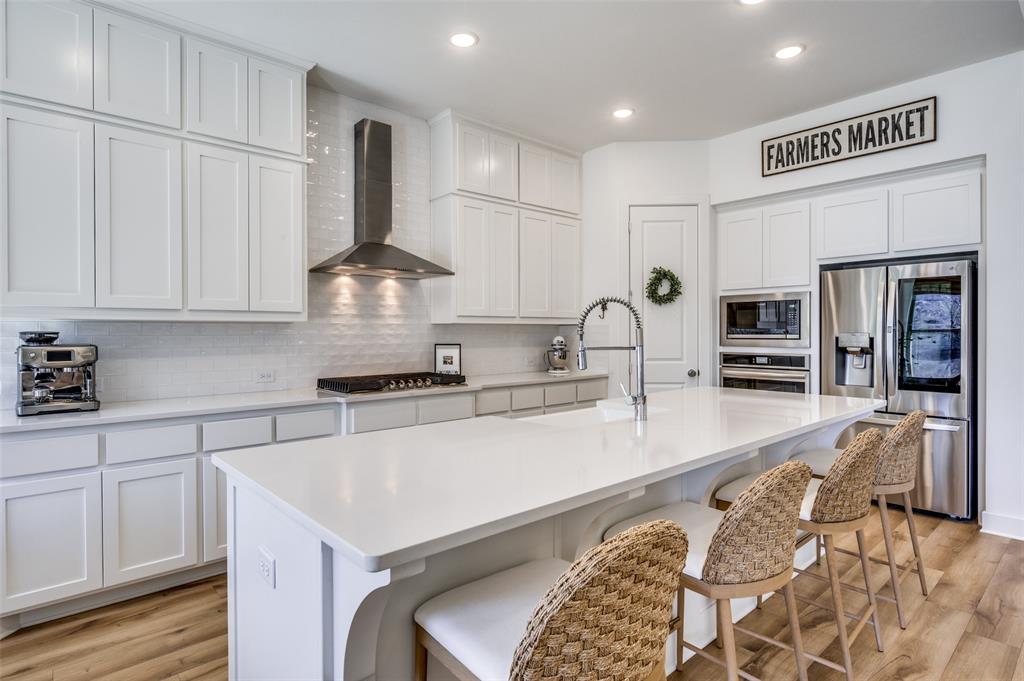 440 Sounding Street Aubrey, TX 76227 - Photo 8 of 40 a kitchen with stainless steel appliances granite countertop a sink stove and refrigerator
