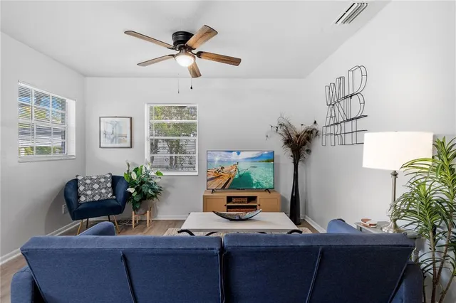 a living room with furniture potted plant and window