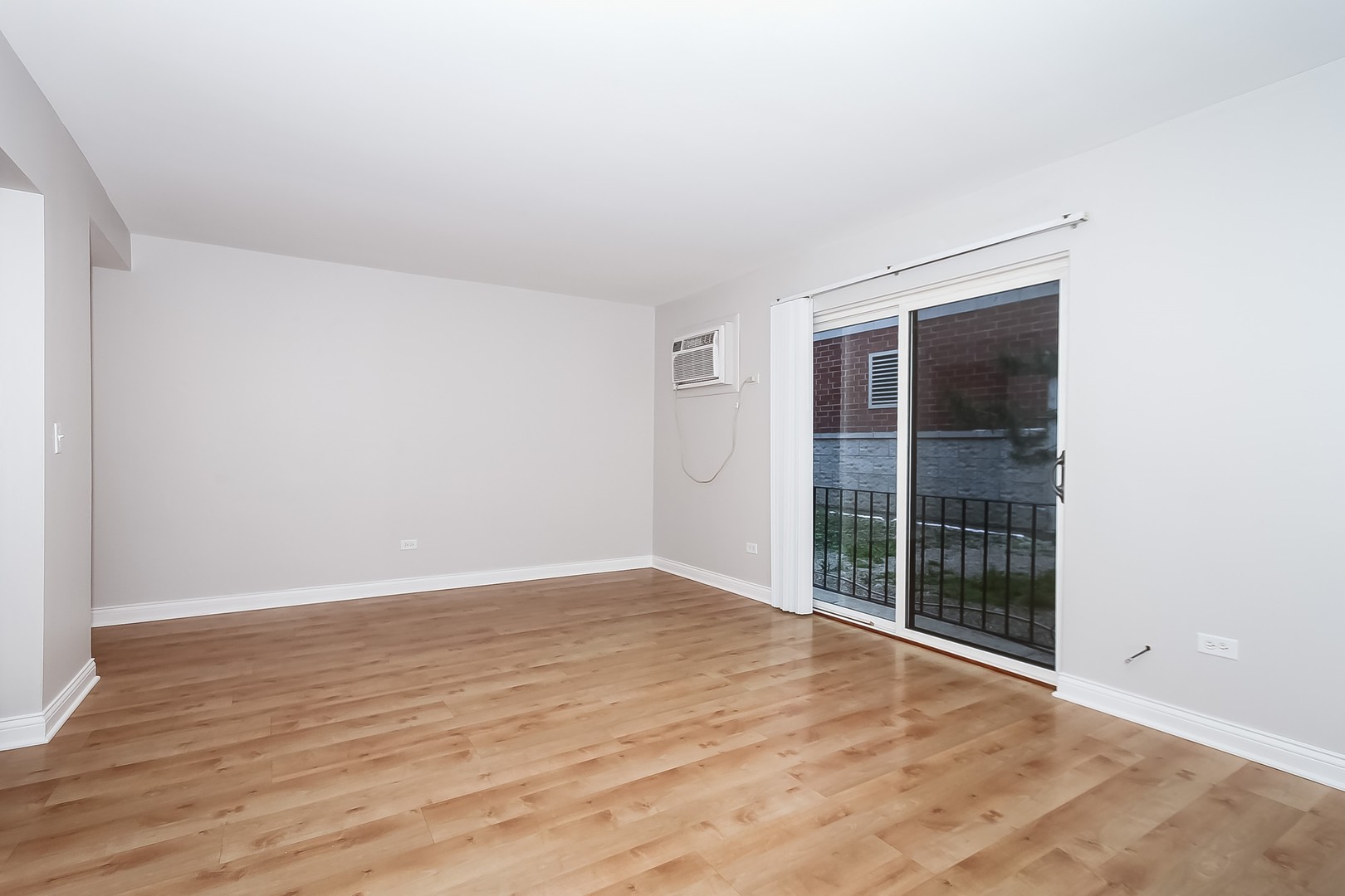 1650 Mill Street, Unit 103 Des Plaines, IL 60016 - Photo 3 of 19 an empty room with wooden floor and windows