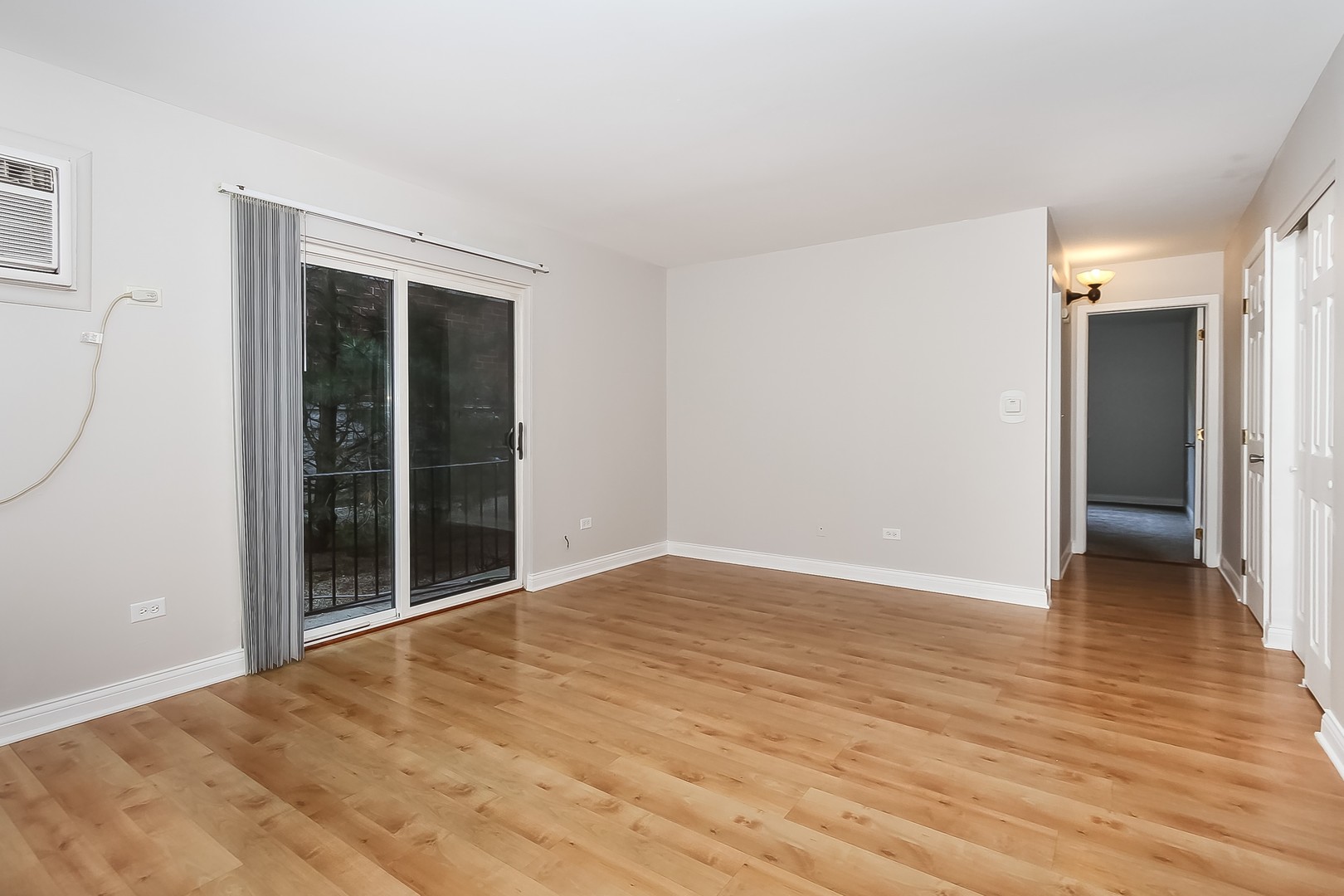 1650 Mill Street, Unit 103 Des Plaines, IL 60016 - Photo 4 of 19 a view of an empty room with wooden floor and a window
