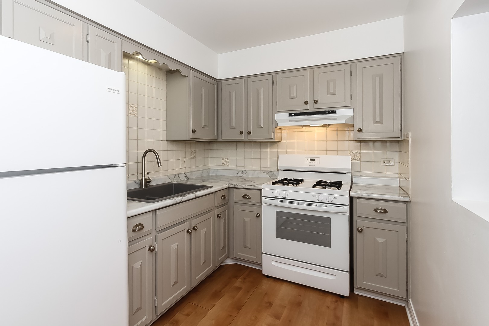 1650 Mill Street, Unit 103 Des Plaines, IL 60016 - Photo 7 of 19 a kitchen with a stove top oven sink and cabinets