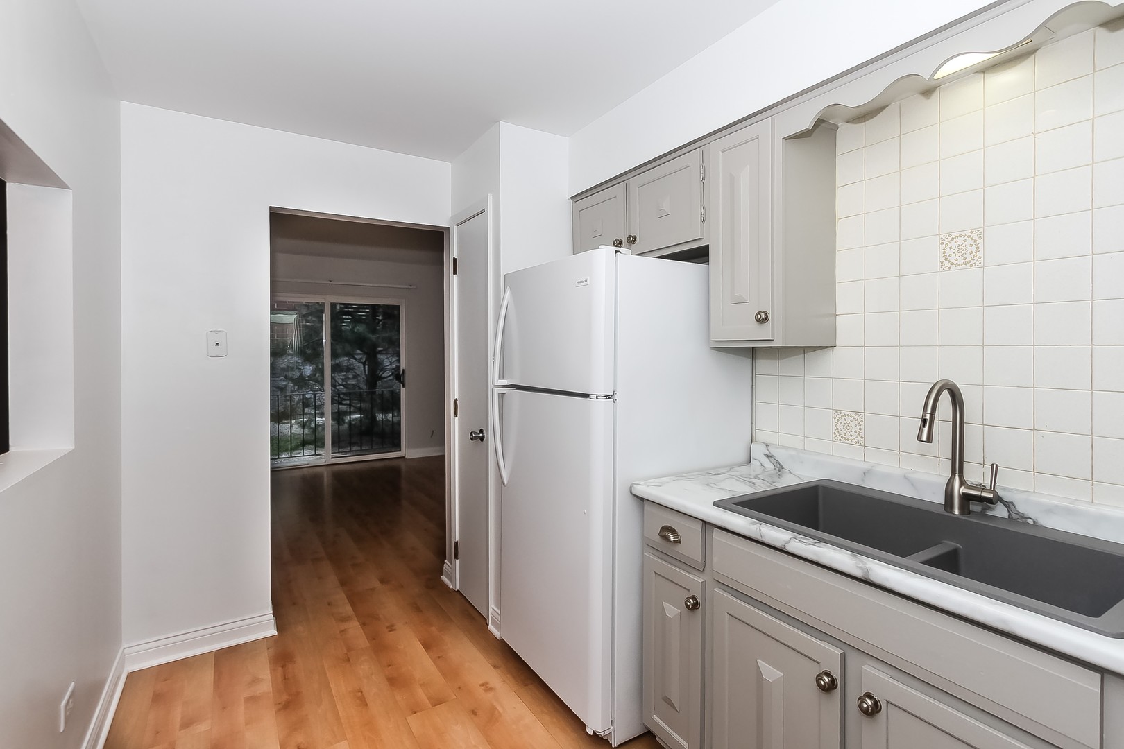 1650 Mill Street, Unit 103 Des Plaines, IL 60016 - Photo 8 of 19 a kitchen with a sink and refrigerator