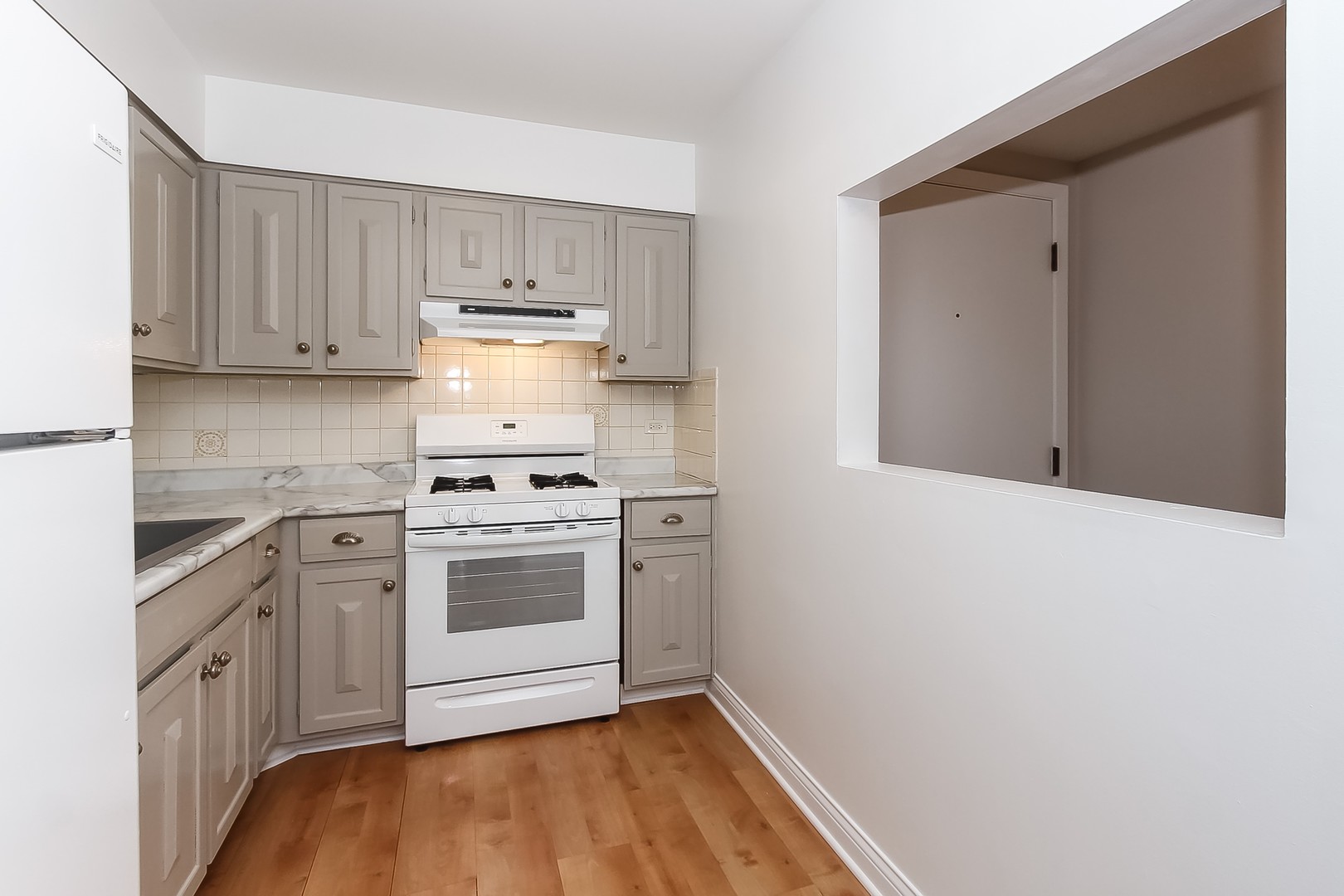 1650 Mill Street, Unit 103 Des Plaines, IL 60016 - Photo 9 of 19 a kitchen with a stove oven and white cabinets