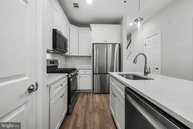 a kitchen with stainless steel appliances a sink microwave and stove