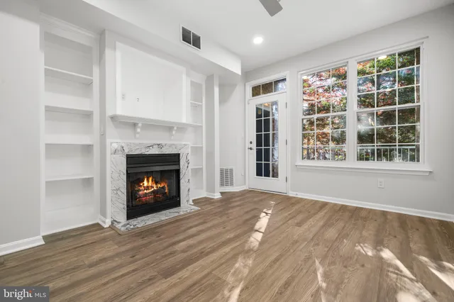 a view of an empty room with a window and fireplace