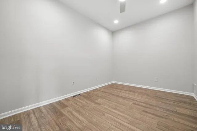 a view of an empty room with wooden floor