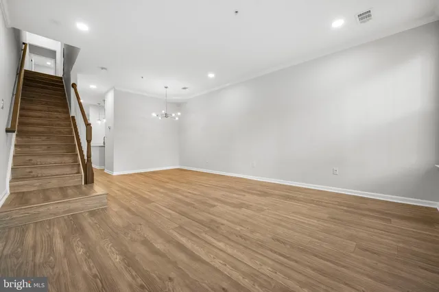 an empty room with wooden floor and entryway