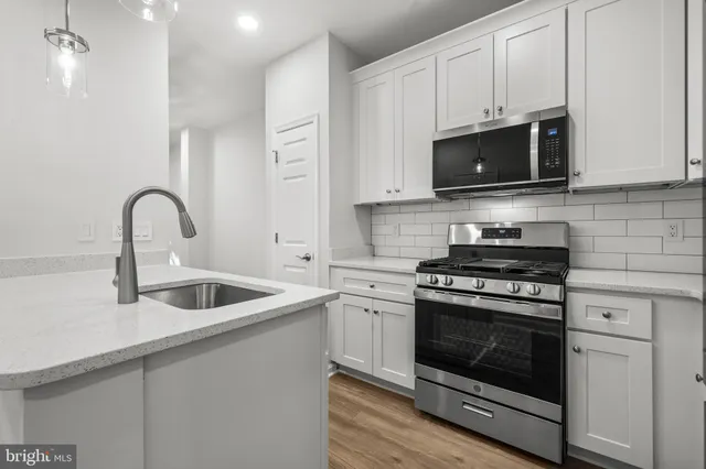 a kitchen with white cabinets and stainless steel appliances