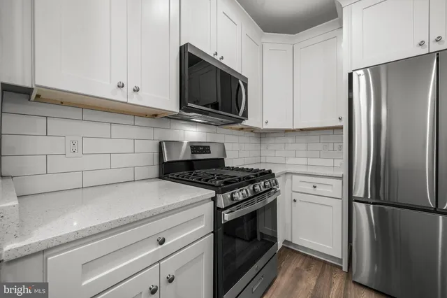 a kitchen with stainless steel appliances a stove microwave and refrigerator