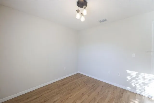 a view of a small space with wooden floor and a window