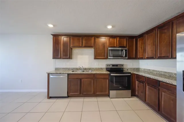 a kitchen with stainless steel appliances granite countertop a stove top oven a sink and dishwasher