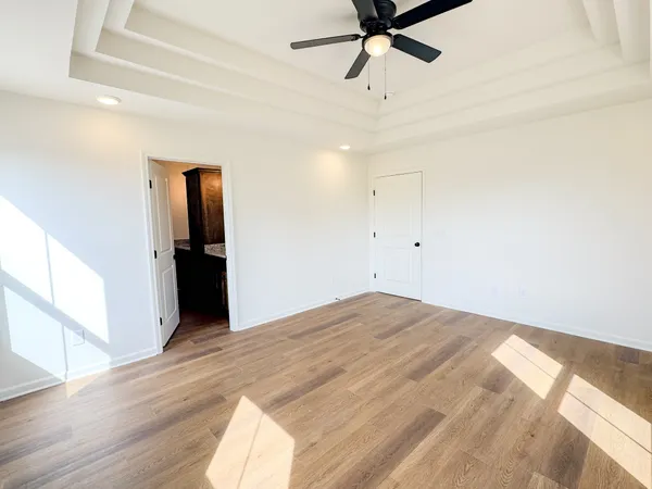 a view of a livingroom with wooden floor and a ceiling fan