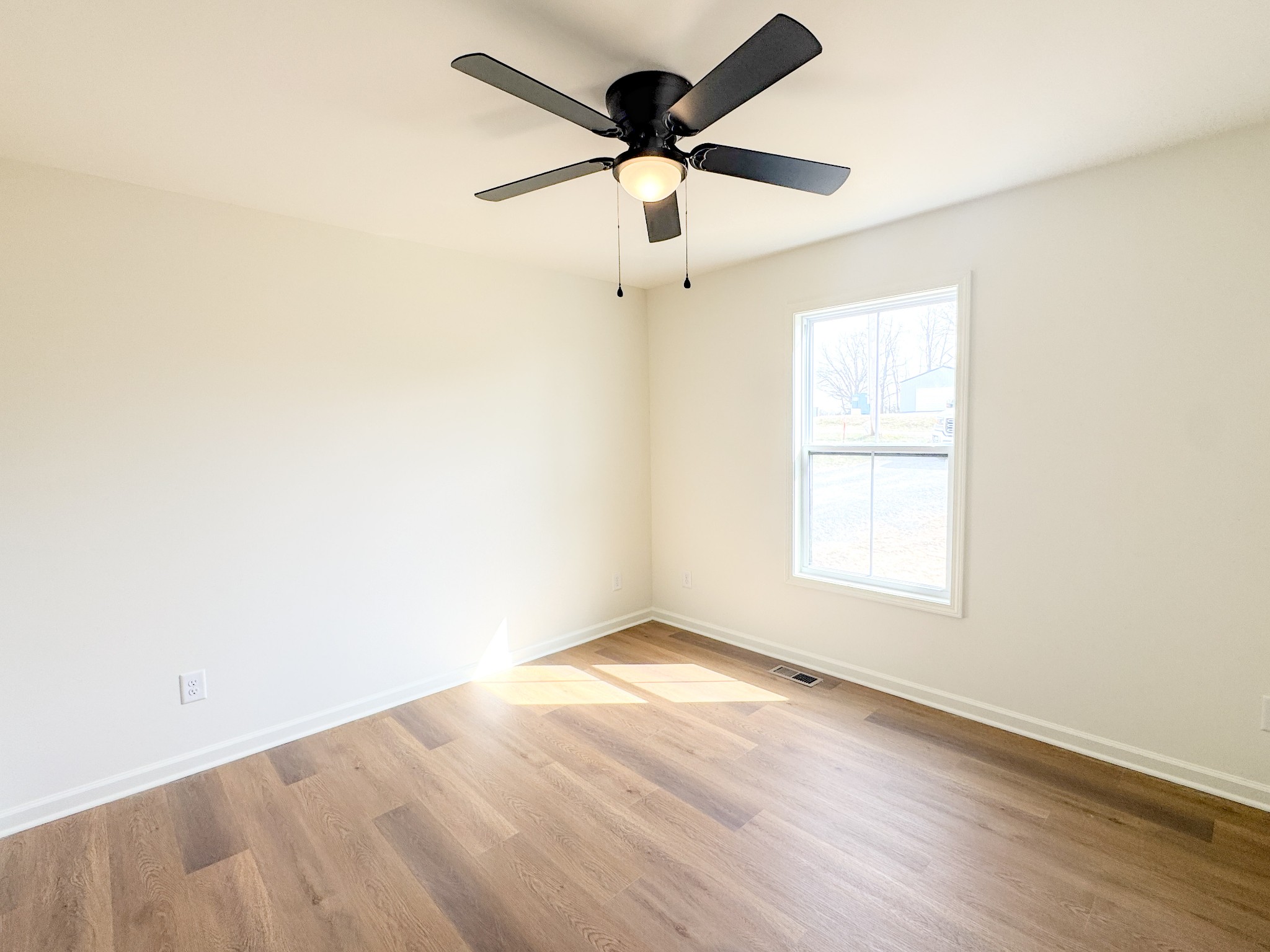 575 Pleasant Hill Road Lafayette, TN 37083 - Photo 26 of 51 an empty room with wooden floor ceiling fan and windows