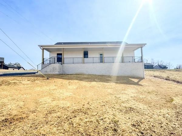 a view of a house with a yard and snow in the background