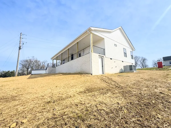 a view of a house with backyard and trees