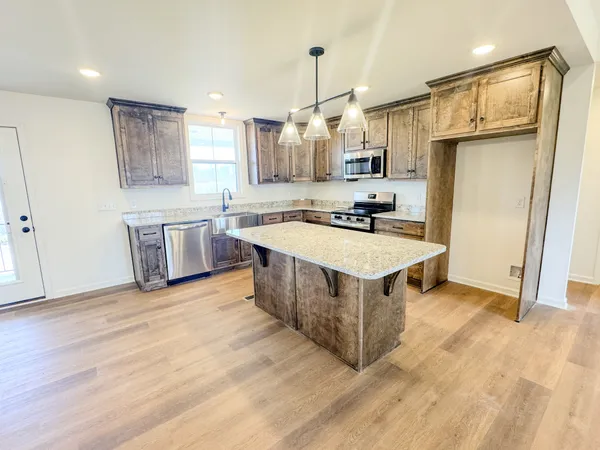a kitchen with stainless steel appliances granite countertop a sink stove and refrigerator