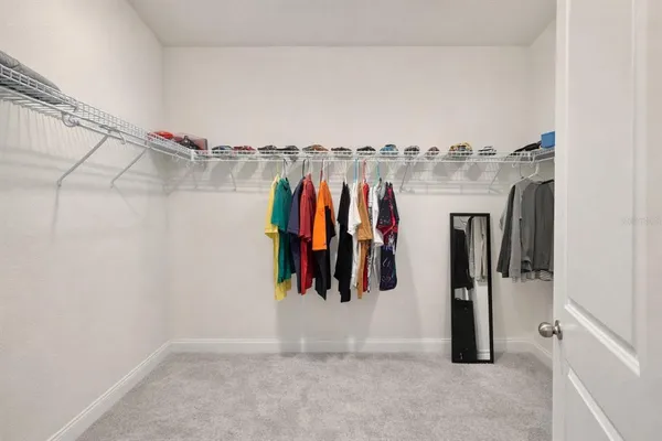 a view of walk in closet with clothes and shoes