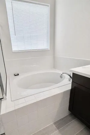 a bathroom with a bathtub and a window
