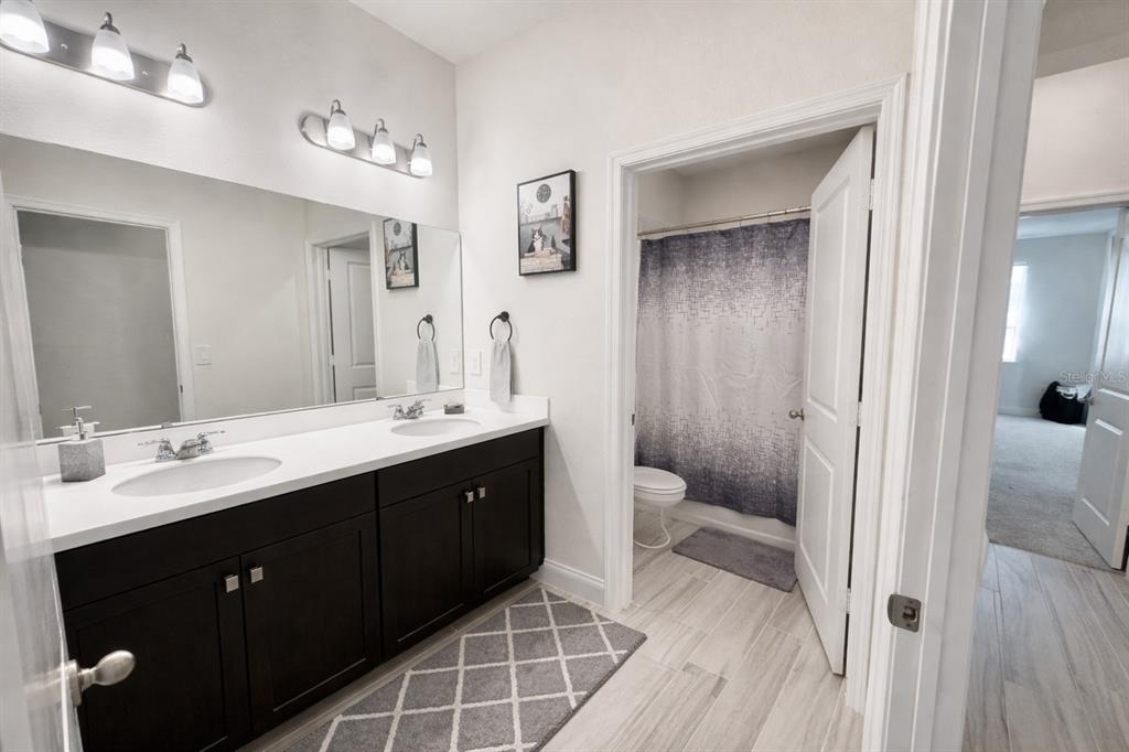 975 Vineyard Rdg Road Minneola, FL 34715 - Photo 18 of 19 a spacious bathroom with a double vanity sink a toilet and a mirror