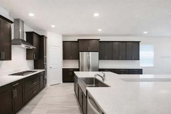 a kitchen with stainless steel appliances granite countertop a sink a stove a refrigerator and cabinets