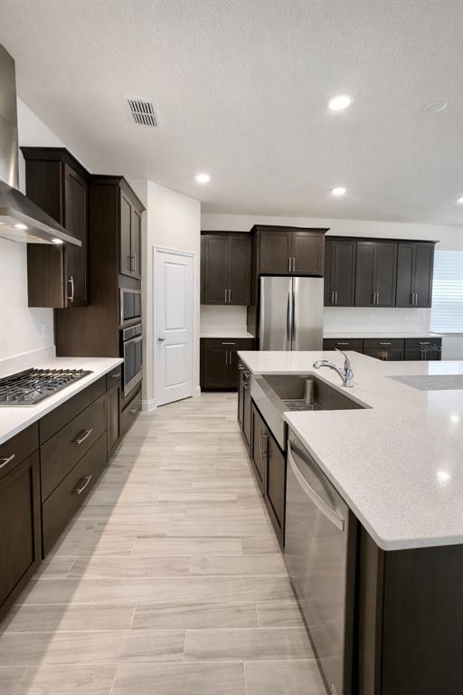 975 Vineyard Rdg Road Minneola, FL 34715 - Photo 4 of 19 a large kitchen with stainless steel appliances kitchen island a sink dishwasher a stove and a refrigerator with wooden floor